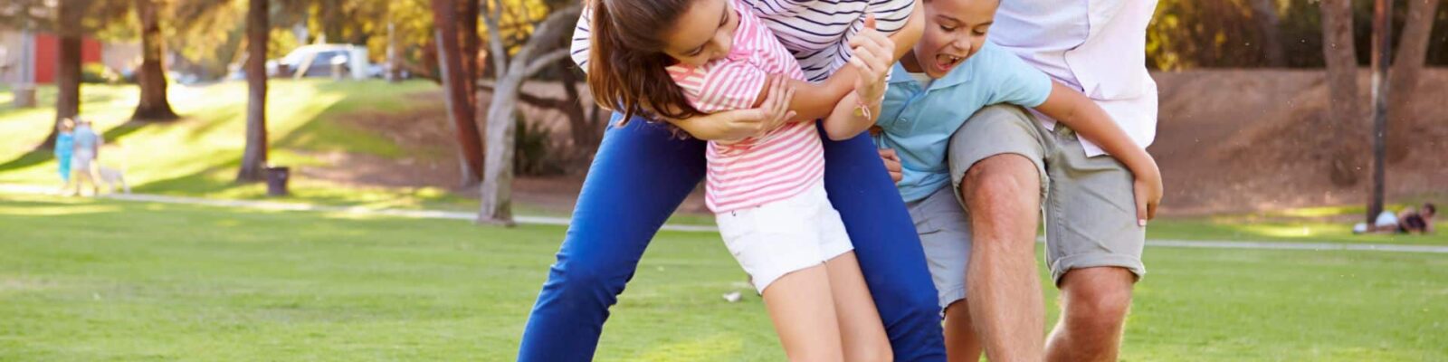 Happy family playing soccer on healthy green lawn in suburban neighborhood outdoor space