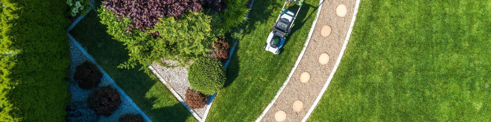 Backyard Garden Grass Mowing Aerial View Aerial view of professional lawn care service treating residential yard with weed-free lawn and landscaped garden beds